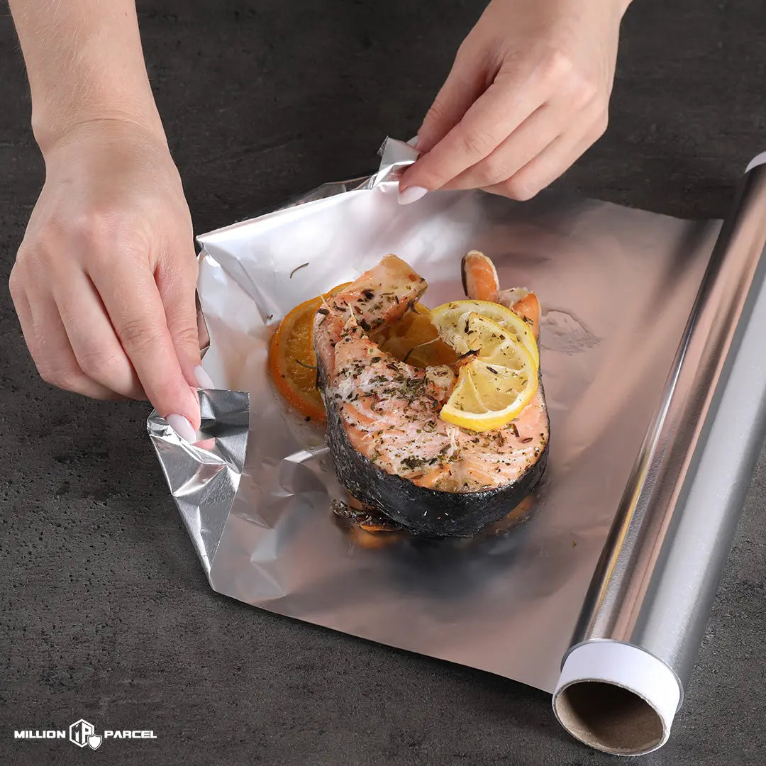 A person wrapping food using aluminum foil