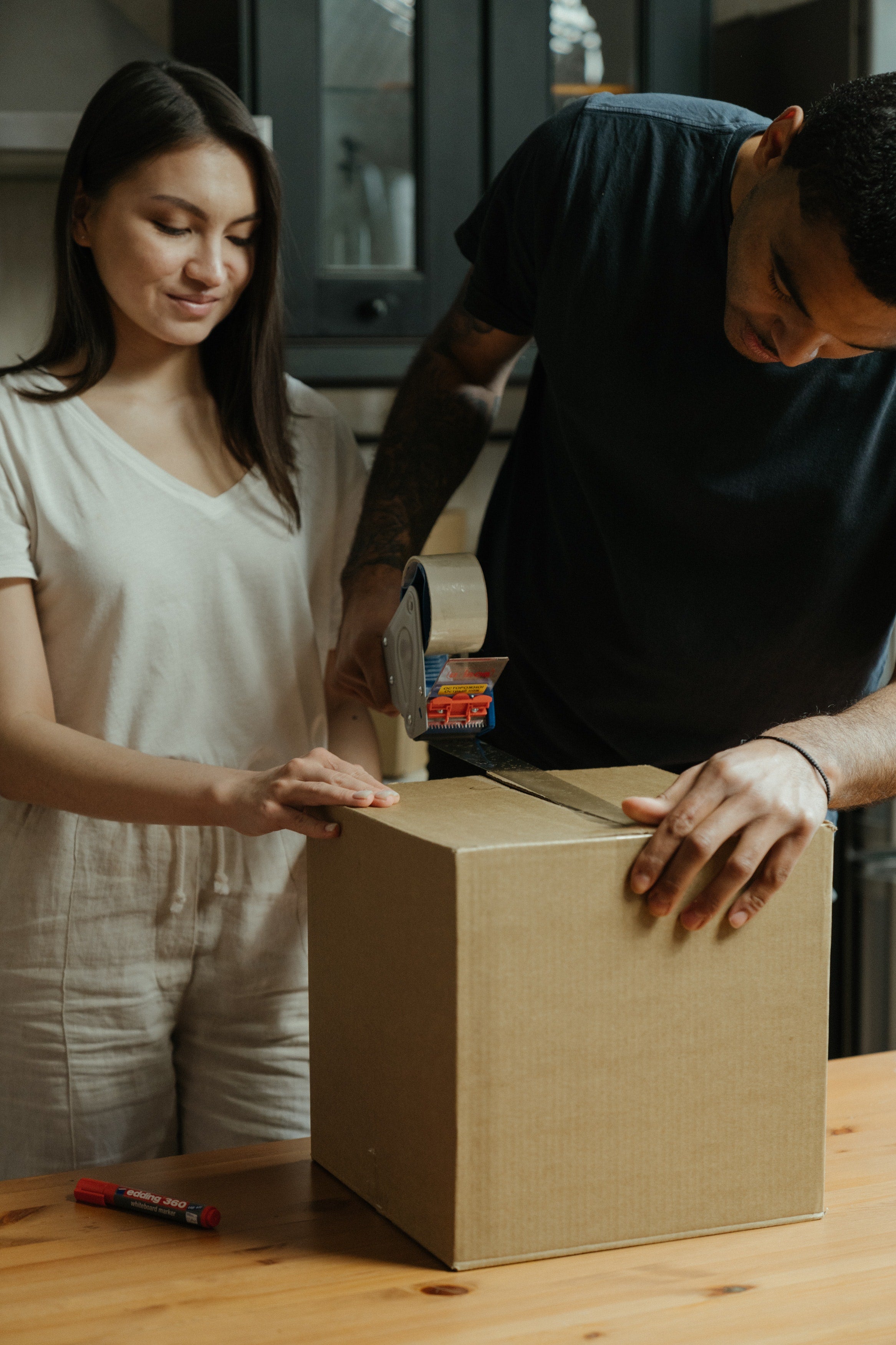A Man And Woman Packing A Box 